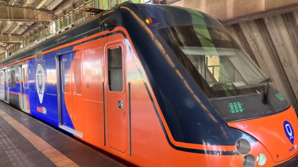 Estação do metrô de Belo Horizonte com plataforma de embarque, trilhos e estrutura coberta aguardando chegada do trem