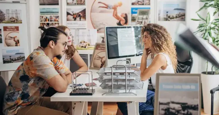 Consultora de viagens apresentando destinos em tablet para cliente, representando o futuro das agências de viagem com tecnologia