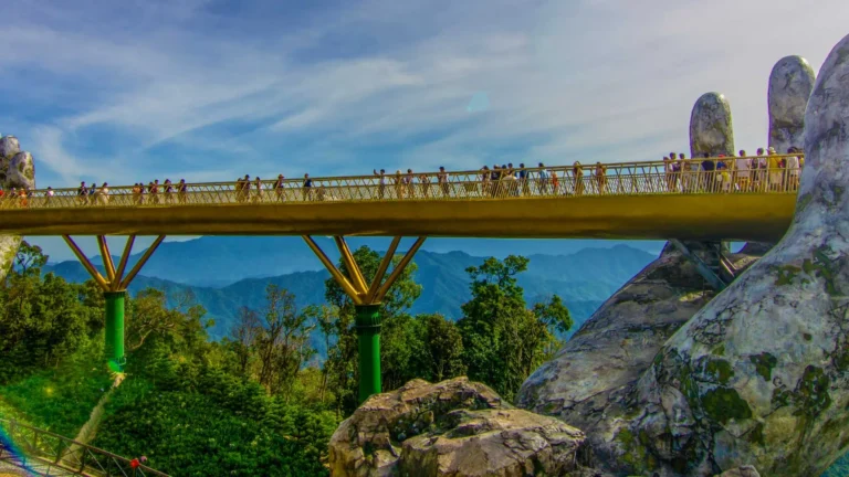 A Ponte Dourada (Golden Bridge) no Vietnã, com muitos turistas, e paisagem montanhosa ao fundo.
