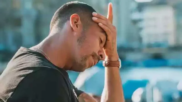 Homem com expressão de frustração e preocupação, segurando a testa com a mão, simbolizando estresse com viagens.