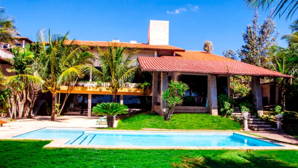 Família sorridente com malas chegando em residência obtida através de troca de casa para viajar, economizando na hospedagem